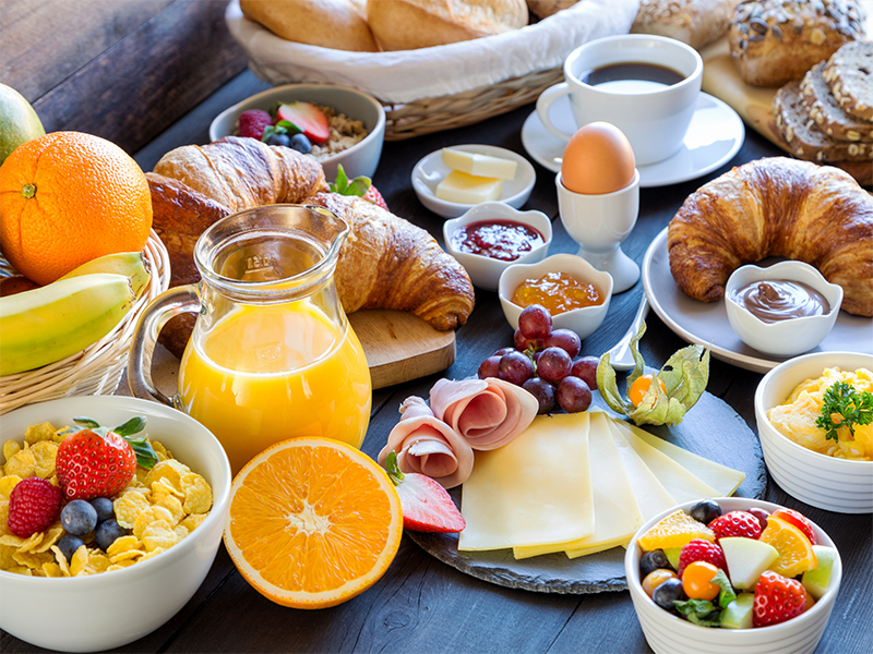 A large breakfast with juice, cereal, fruit and pastries