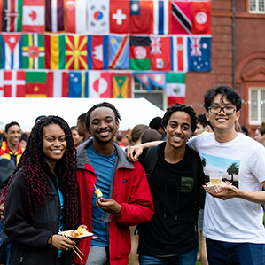 A group of students holding food with flags in the background