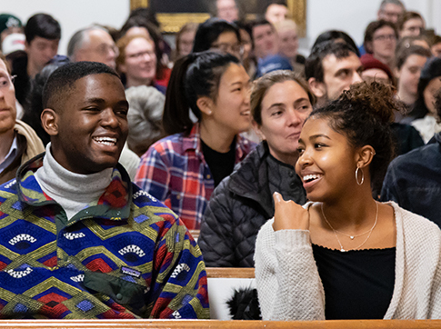 Two students laughing and sitting together in Johnson Chapel
