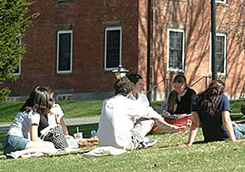A group of students sits outside on the Amherst College campus