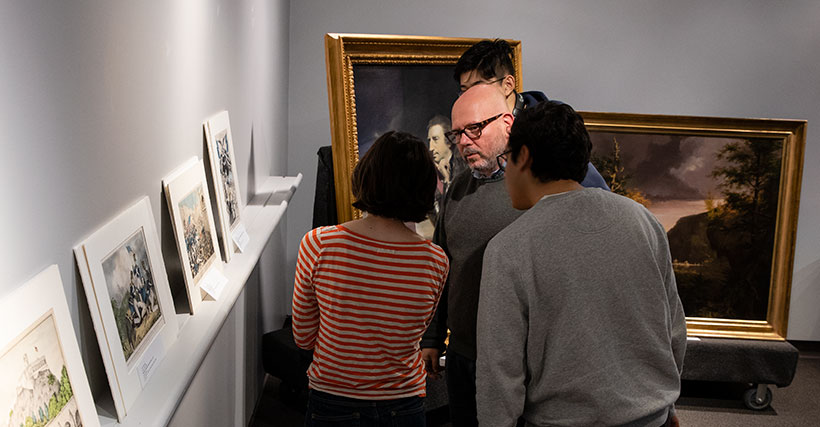 Students and their professor examining artwork in an art museum