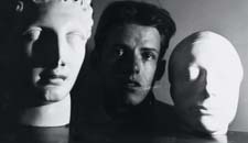 James Merrill ’47 posed between a scultpure of a Hermes and a life mask of Keats.