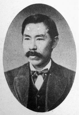 A black and white photo of Niijima Jo, a Japanese man with short hair and a mustache. He is wearing a suit and bowtie.