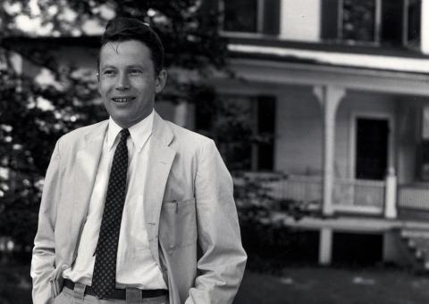 Black and white portrait of young Richard Wilbur wearing a gray suit and black tie