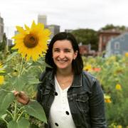 Carmen Granda in a field of flowers smiling at camera