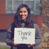 Student holding a "thank you" sign