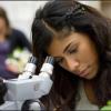 Female student working at microscope.